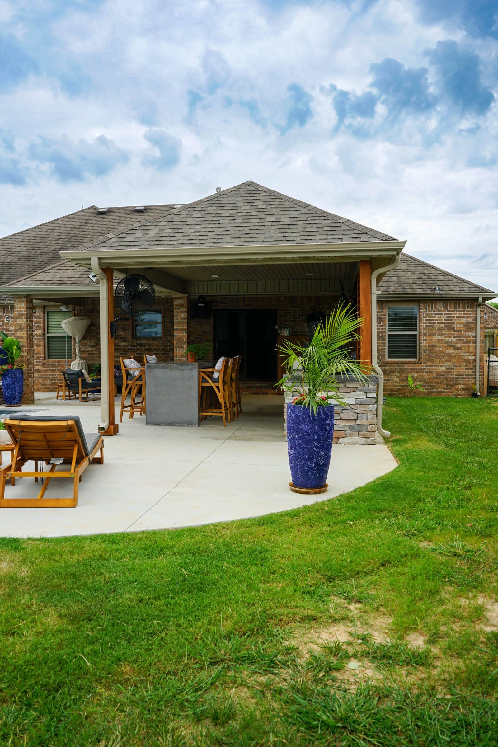 The covered structure and pool seen across the lawn